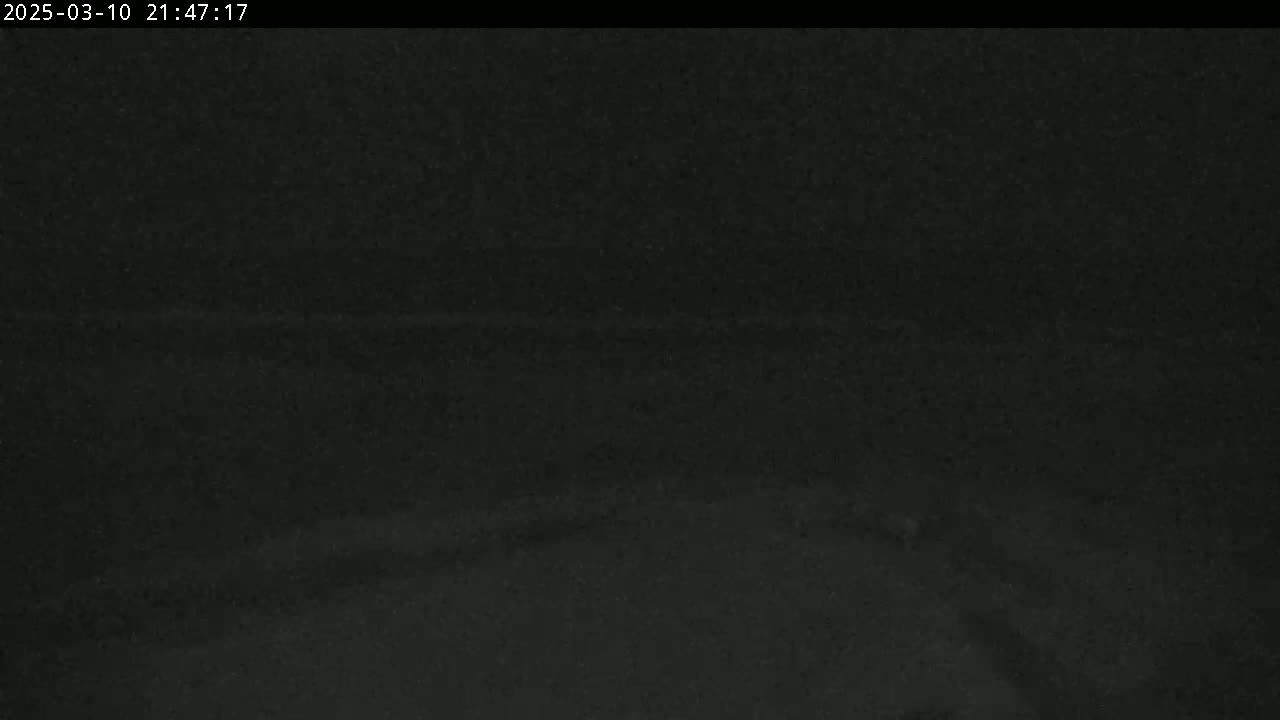 A dark, nighttime scene shows a mostly featureless expanse of land.