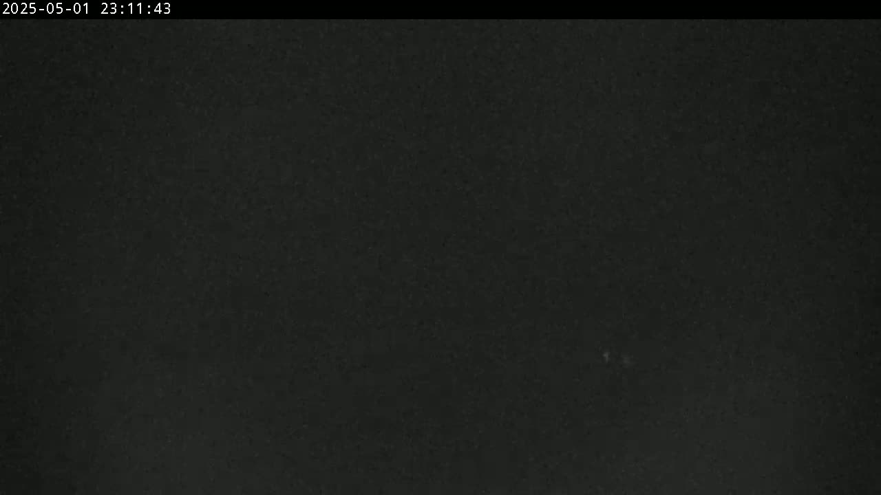 A dark, possibly nighttime, image shows a mostly uniform black surface with slight variations in shading.