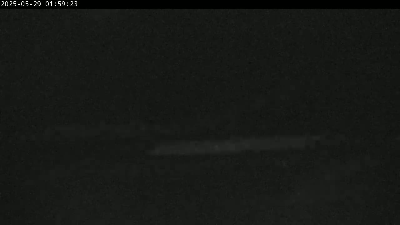 A very dark, blurry image shows a faint, horizontal line near the bottom, likely a road or ground level under nighttime conditions.