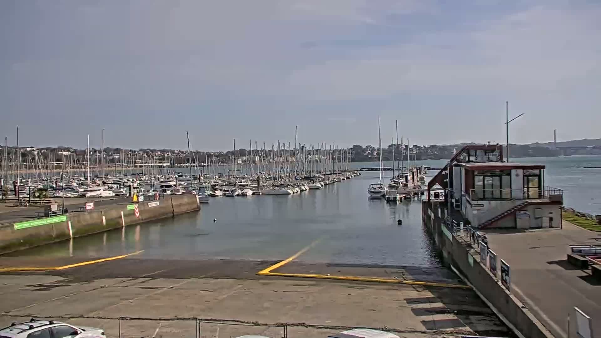 A marina filled with sailboats under a mostly sunny sky.