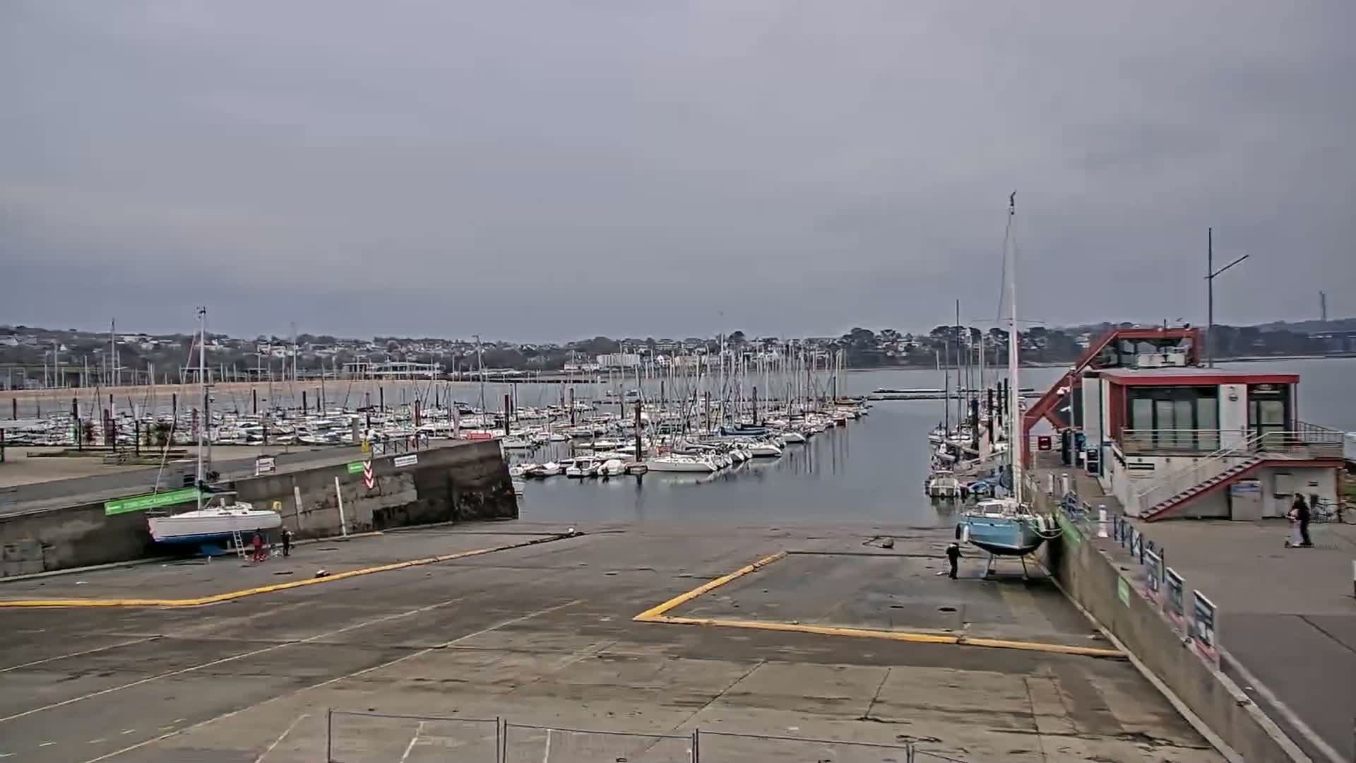 A marina filled with sailboats under an overcast sky.