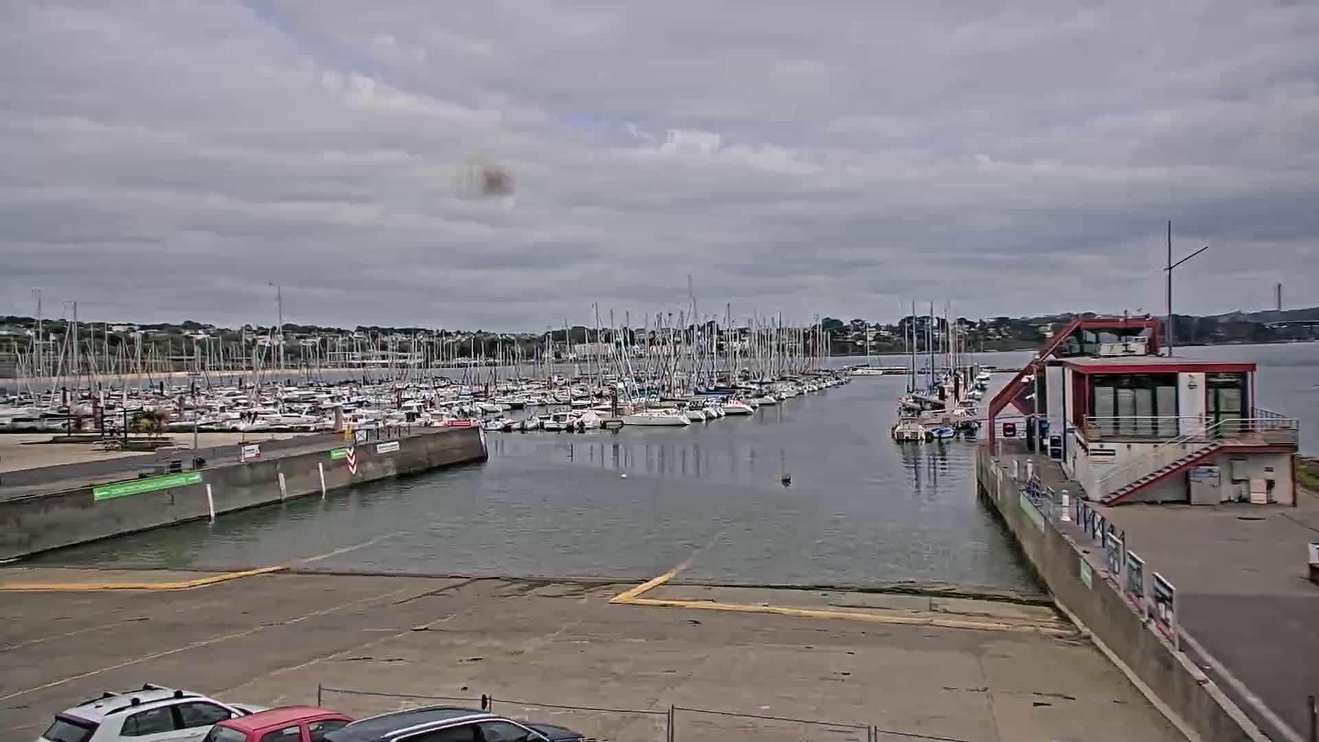 A marina filled with sailboats under a cloudy sky.