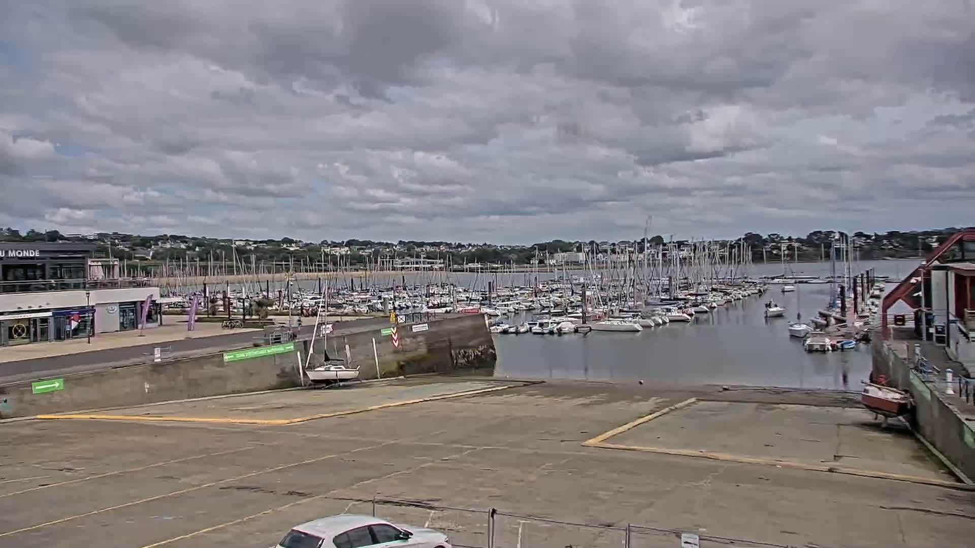 A marina filled with numerous sailboats under a cloudy sky.