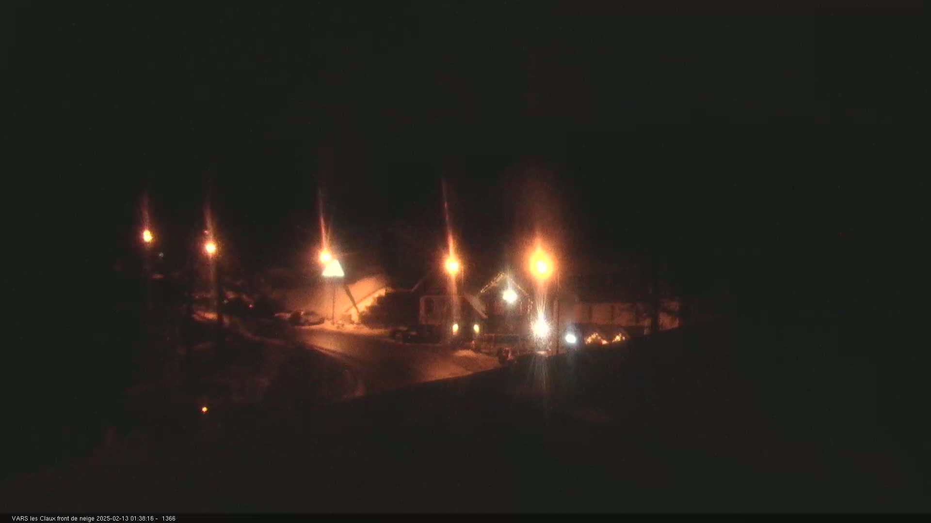 Several illuminated buildings and streetlights are visible at night in a snow-covered area.