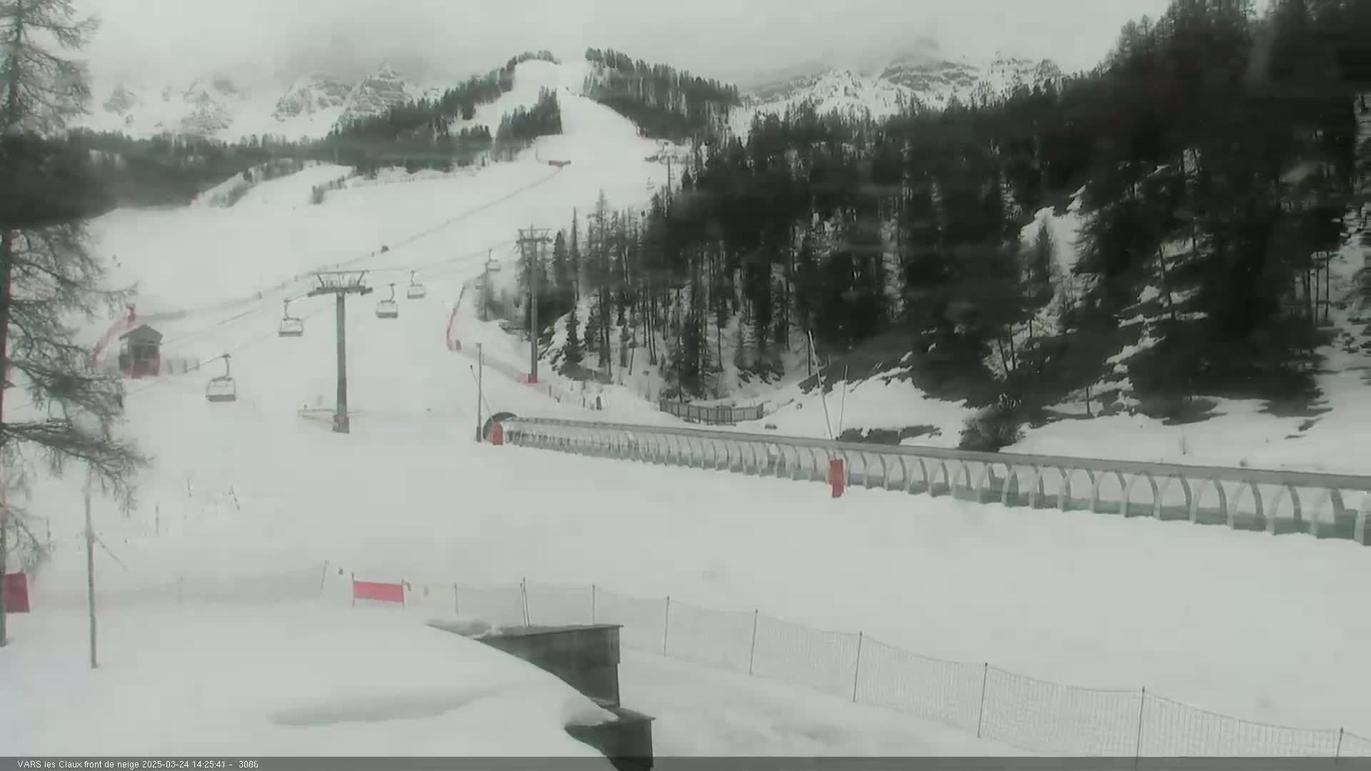 A snow-covered ski slope with a chairlift and a snow tubing run is visible under an overcast sky.