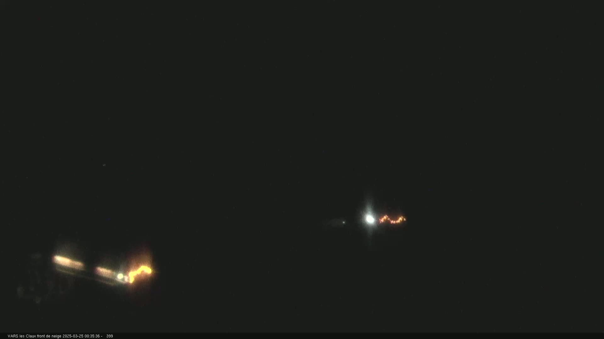 At night, faint orange and white lights appear in the dark sky, possibly indicating distant lights or atmospheric phenomena.