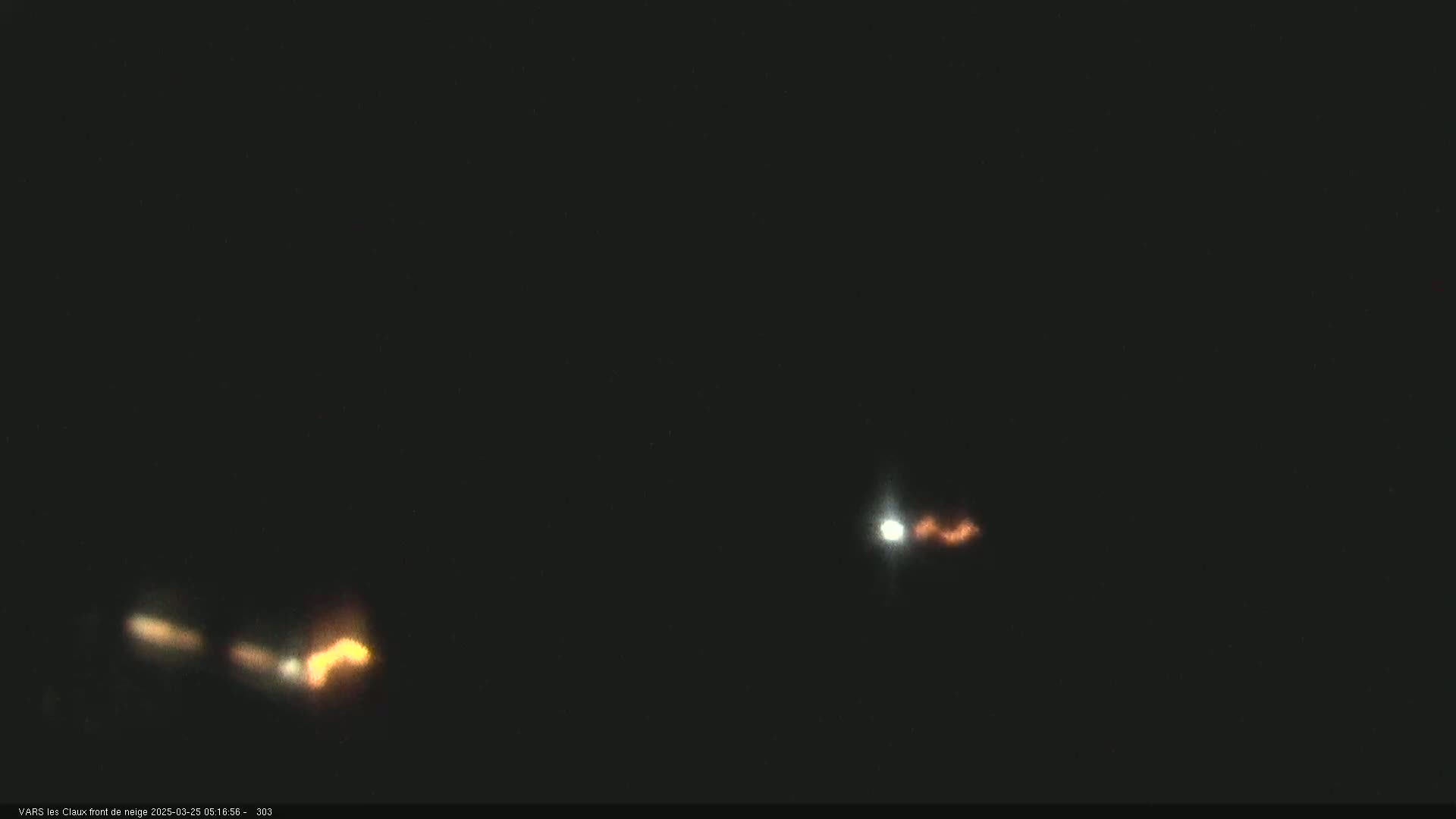 Two blurry, bright lights are visible in a dark, nighttime sky.