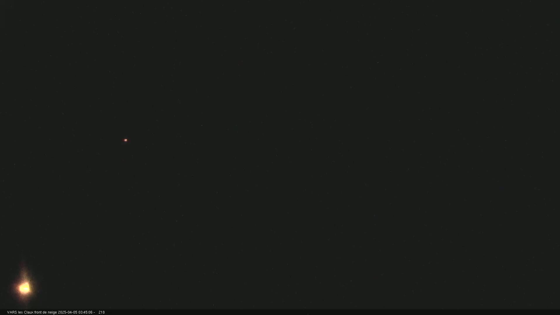 A dark night sky shows two faint lights, one brighter and yellowish-white, the other smaller and reddish.