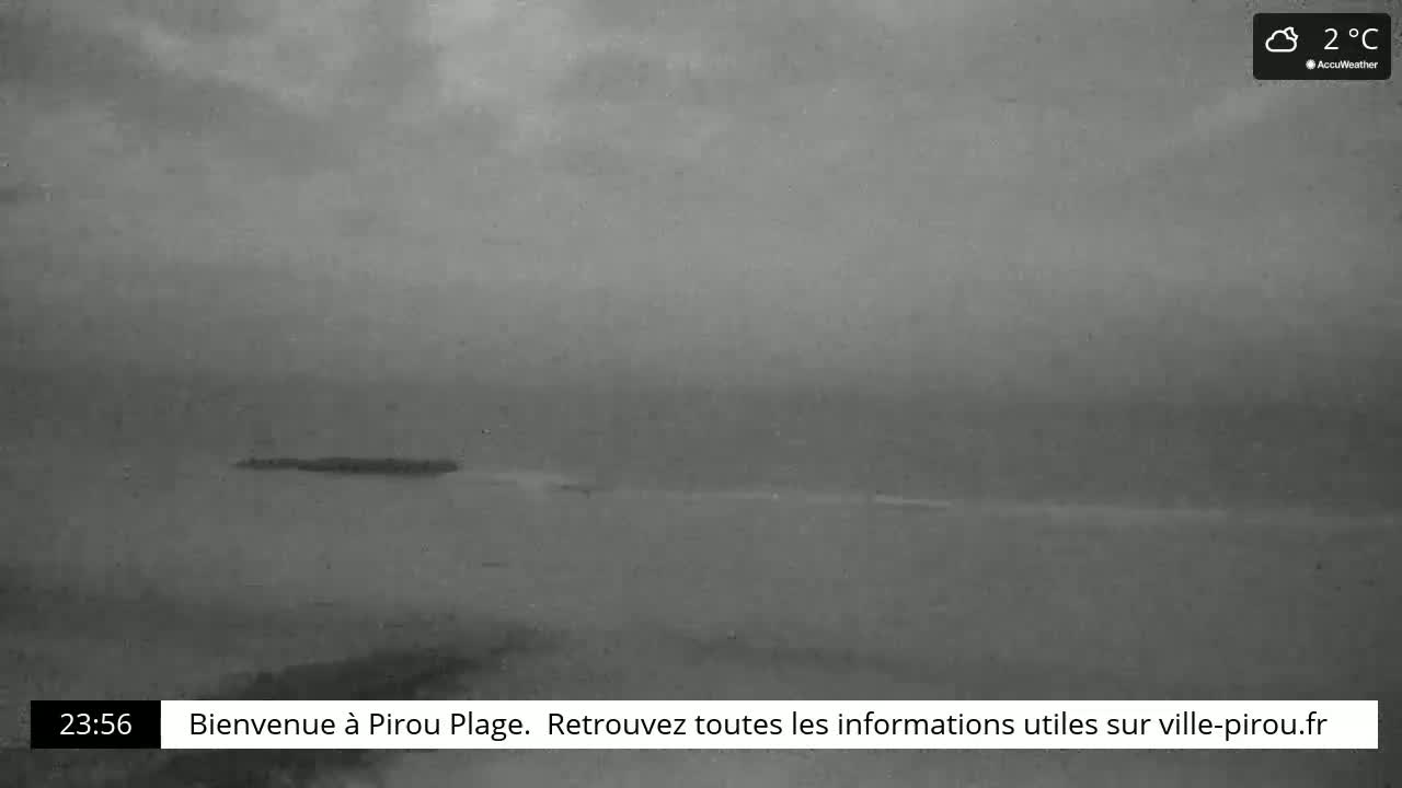 A long, dark, flat expanse of water is visible under an overcast sky, with a small, dark island in the distance.