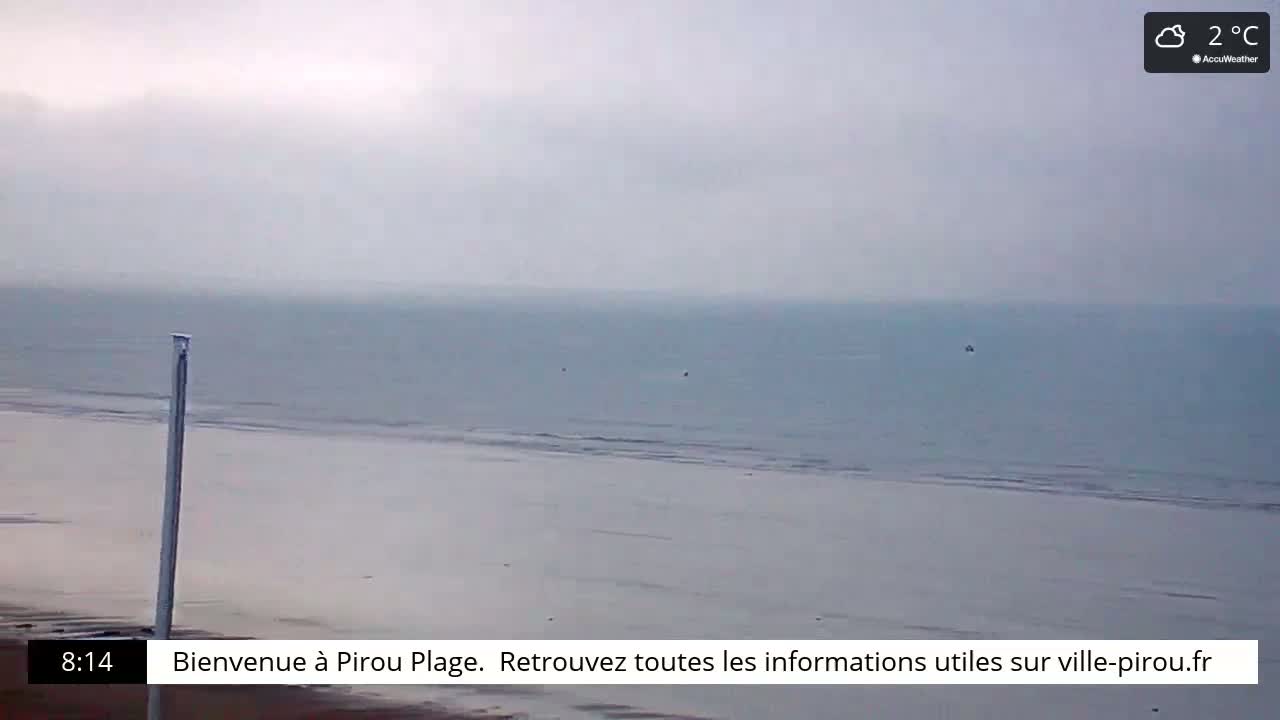 A mostly overcast sky hangs over a calm, gray sea and a flat, sandy beach.