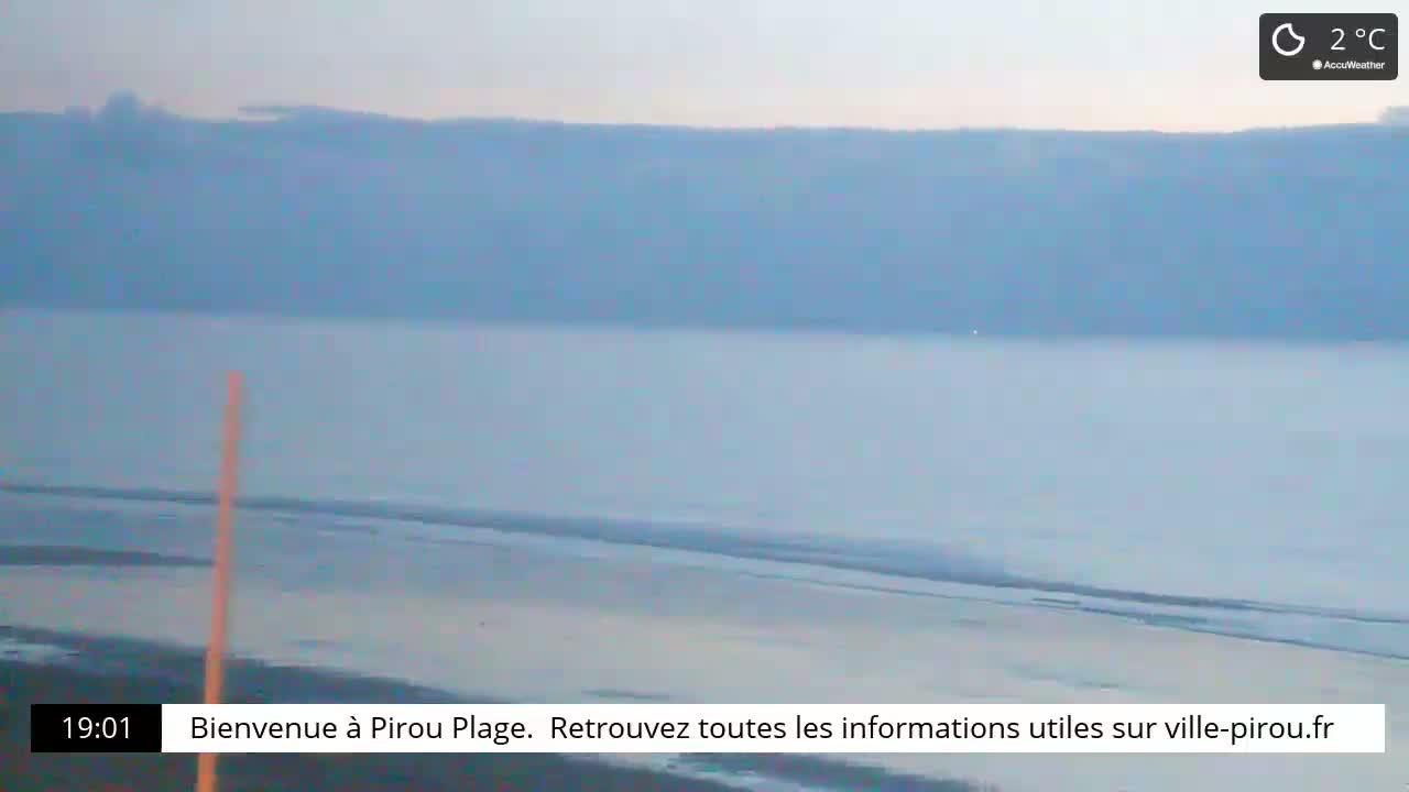 A flat, light-blue body of water stretches to a hazy horizon under a pale, overcast sky, with a temperature of 2°C.