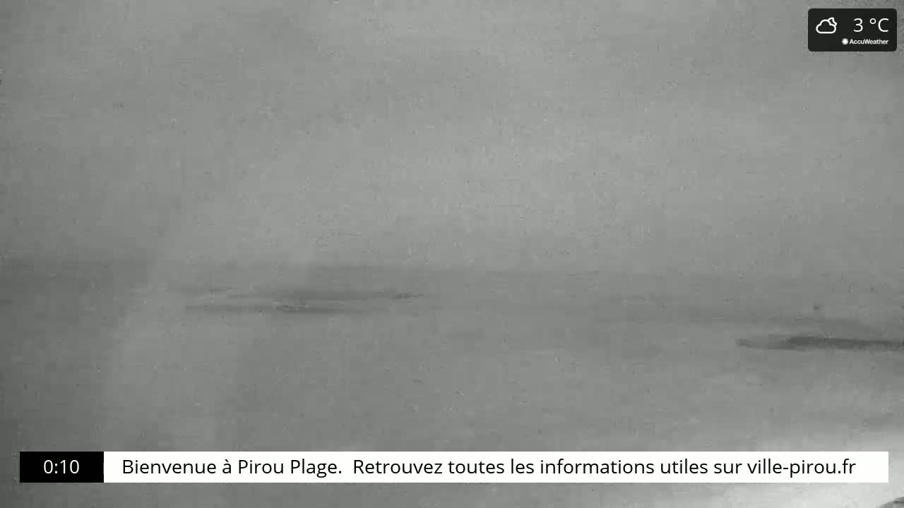 A cloudy, gray day is shown with a calm body of water extending to the horizon.