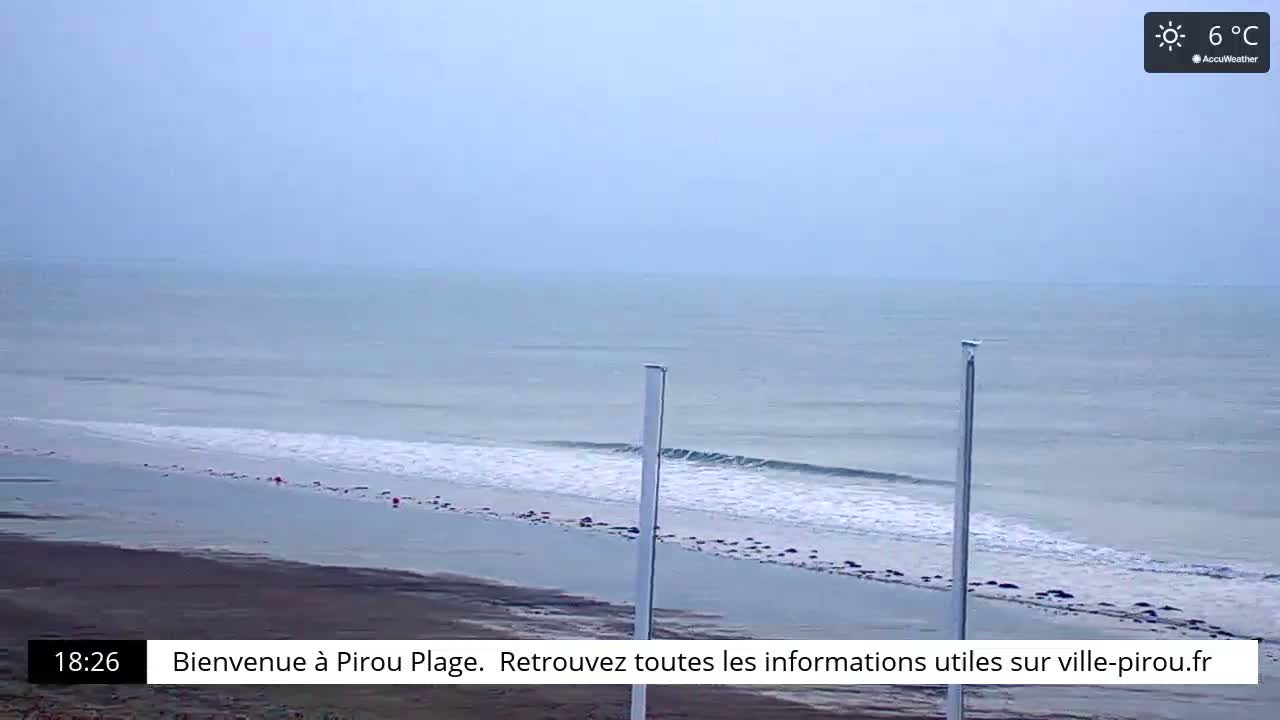 A beach with gently rolling waves under a slightly overcast sky, on a 6°C day.