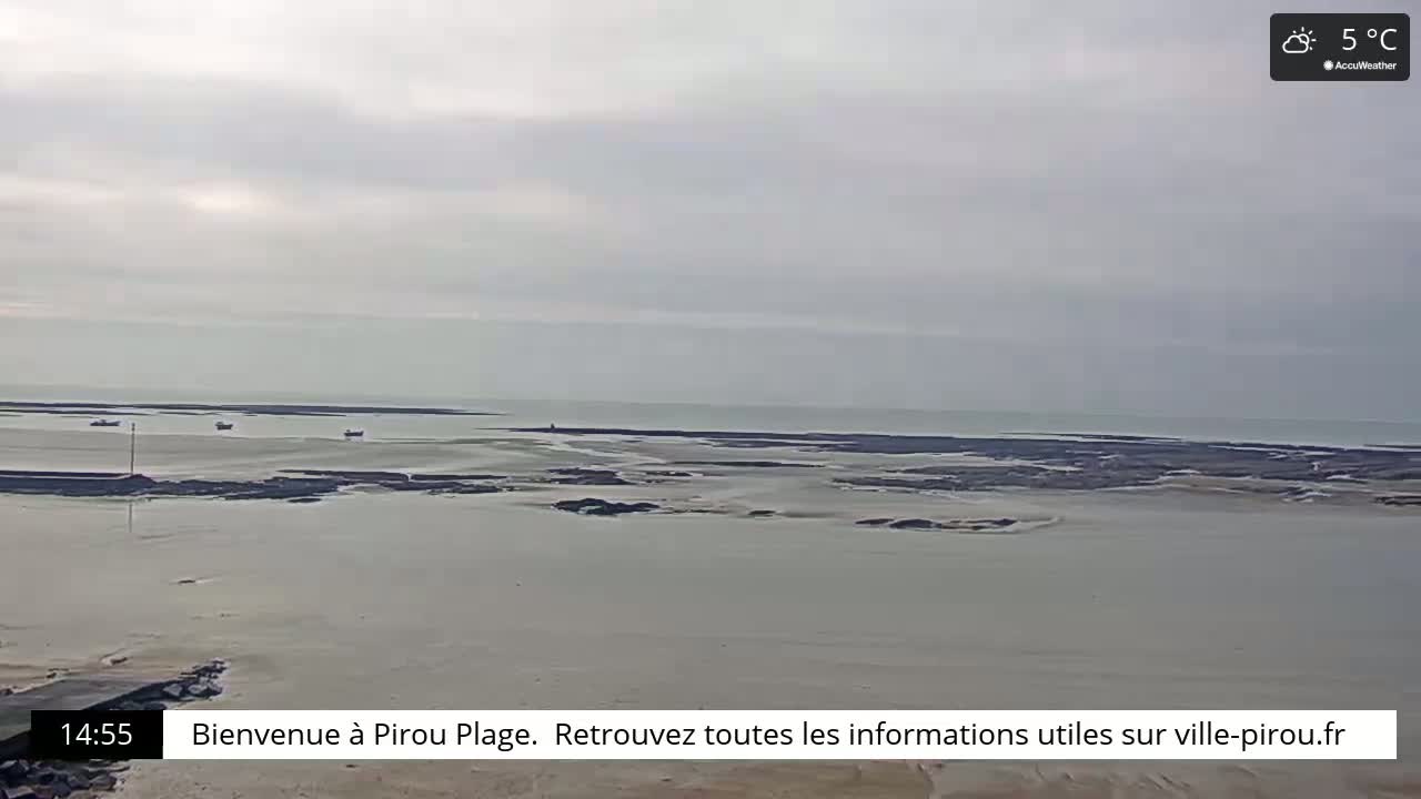 A mostly cloudy, 5°C day reveals a wide expanse of shallow, calm water with several small boats near the shore and a distant coastline.