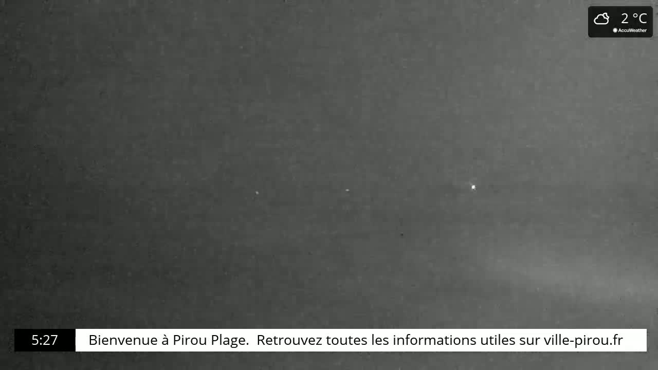 A nighttime, cloudy outdoor scene shows a dark gray sky with a few small, bright lights visible in the distance at 2°C.