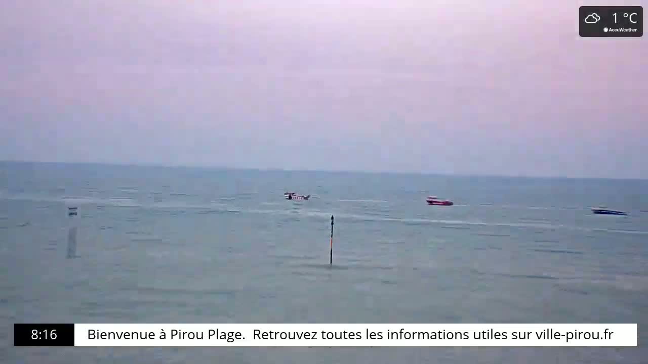A calm, cloudy sea with three small boats is visible on a slightly overcast day at 1°C.