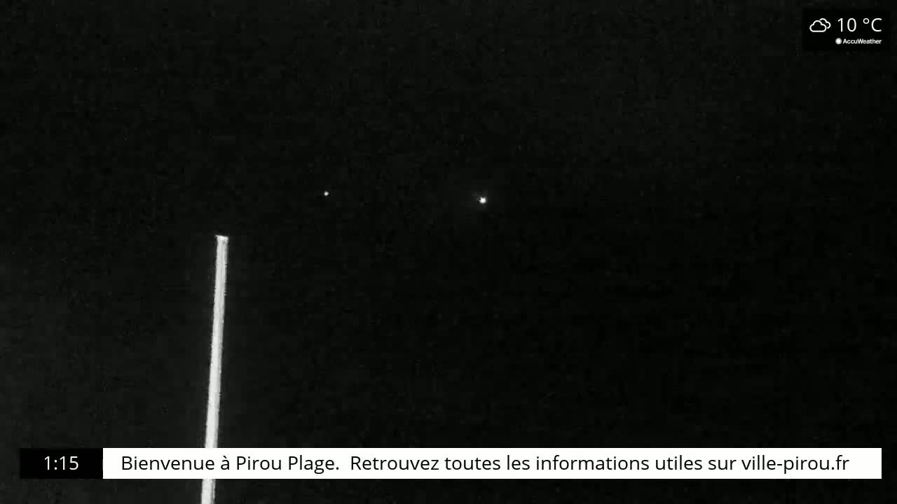 A nighttime, mostly clear outdoor scene shows three bright lights in the sky and a tall, thin, vertical light source on the left.