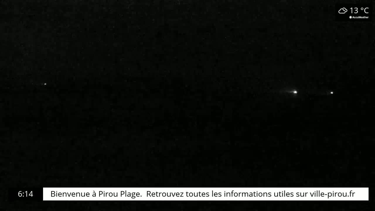 A dark, nighttime scene shows a few distant lights in the far horizon under a cloudy, 13°C sky.