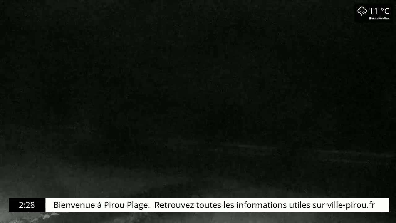 A dark, nighttime scene shows a very dimly lit beach under rainy conditions at 11°C.