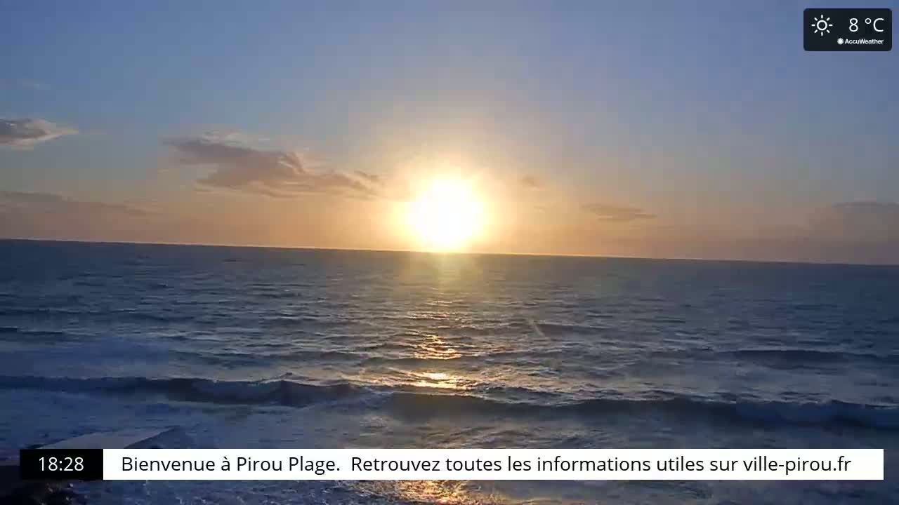 A bright sun sets over a calm ocean with small waves.