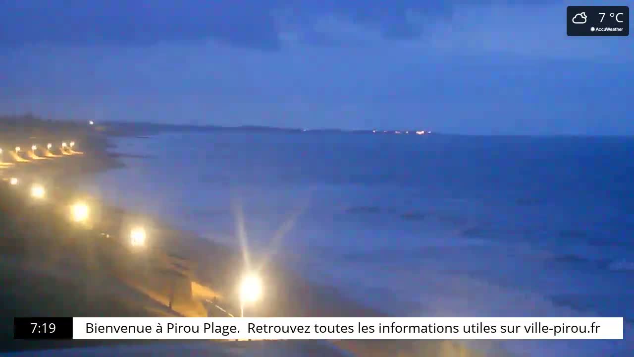 A dark-blue ocean meets a dimly lit beach at dusk under a mostly clear sky, with a temperature of 7°C.