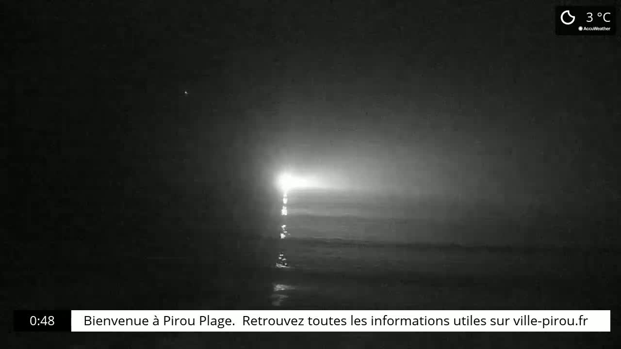 A bright light shines over dark, still water at night in foggy conditions, with a temperature of 3°C.
