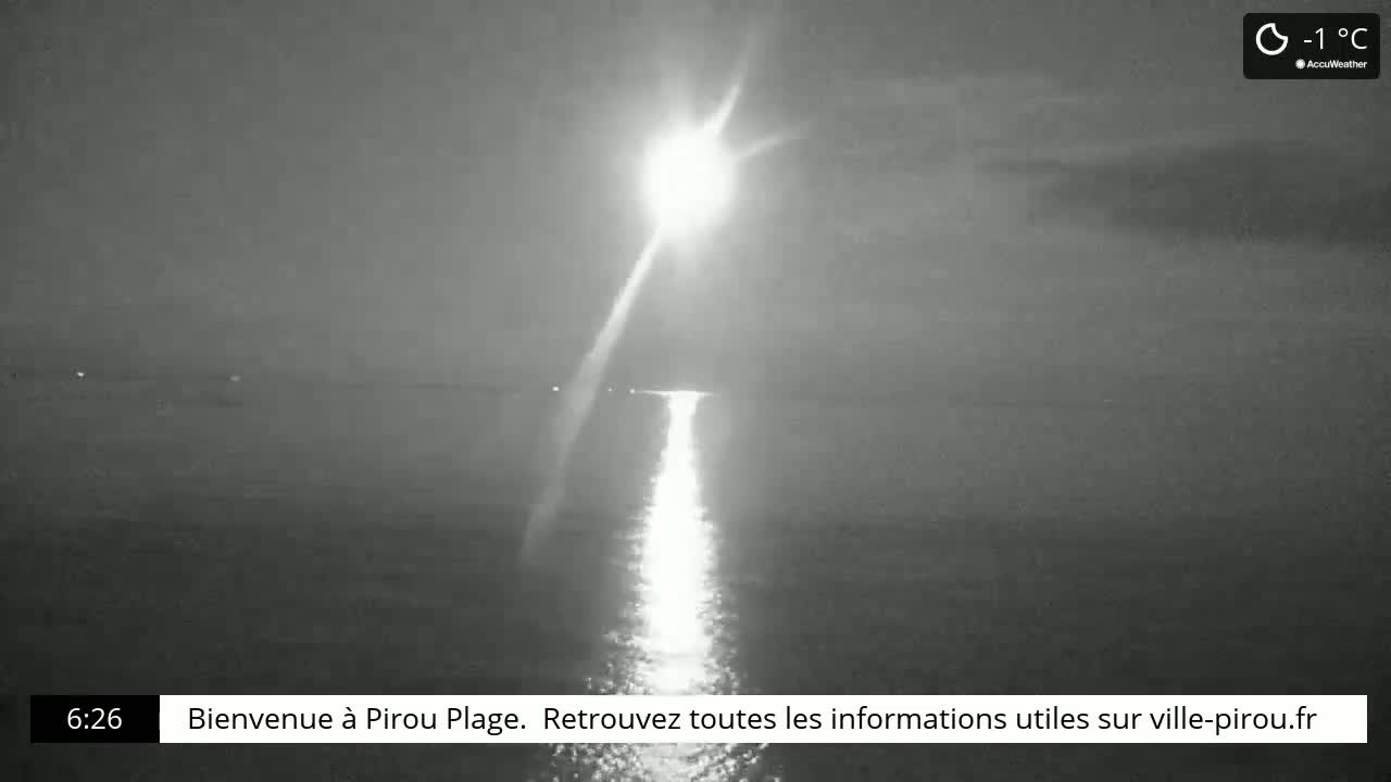 A bright light reflects on a calm body of water at night in -1°C weather.