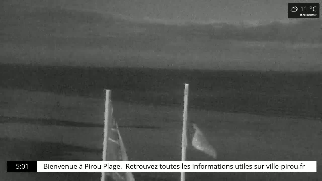 A cloudy, 11°C outdoor scene shows a beach with two flagpoles and flags near the water.
