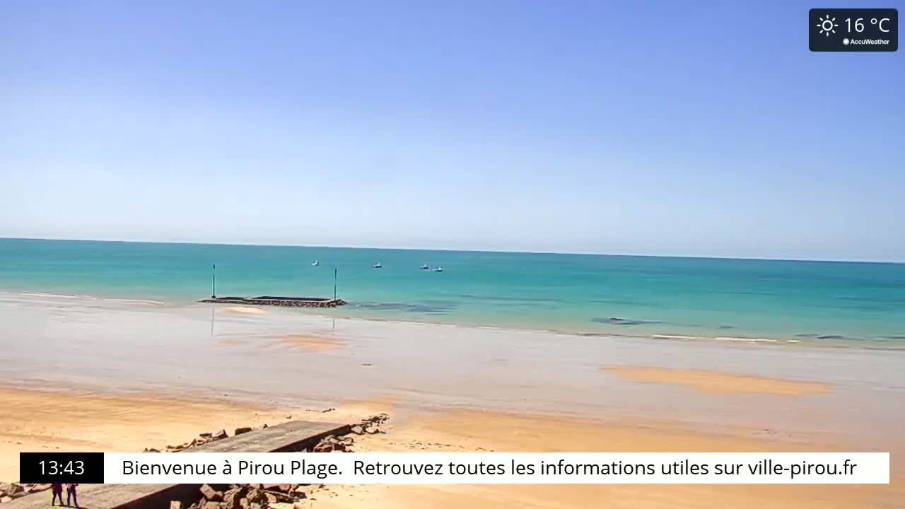 A sandy beach stretches to a calm, turquoise ocean under a clear, sunny sky.
