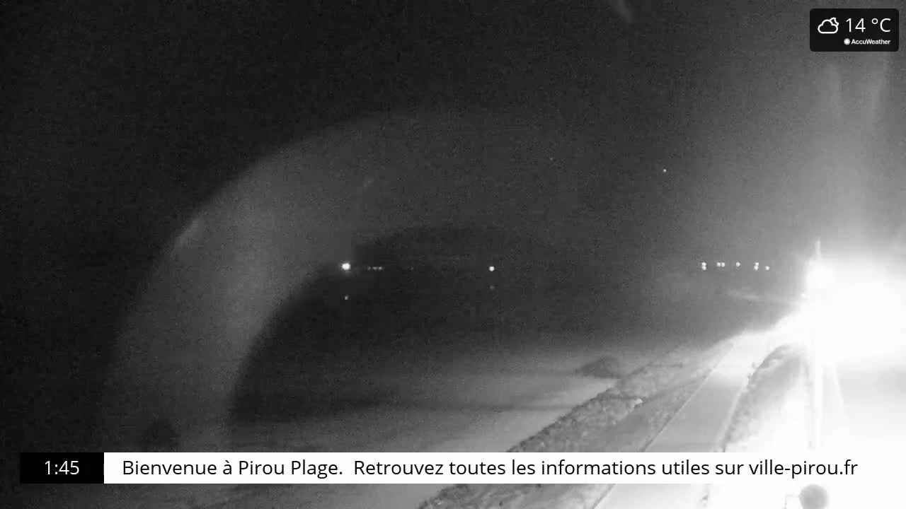 A nighttime, low-light view of a dark road and a flat, possibly snowy, landscape at 14°C.