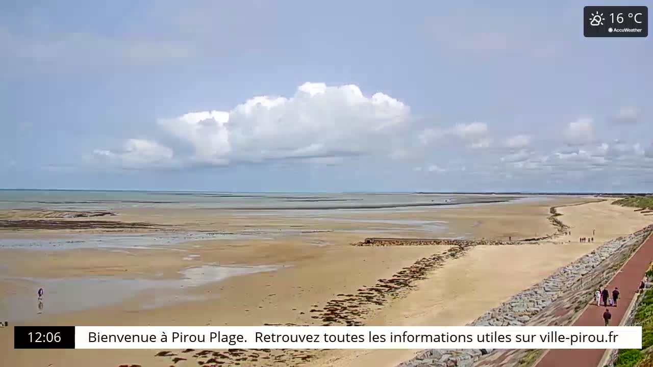 A wide sandy beach stretches to a calm ocean under a partly cloudy sky.