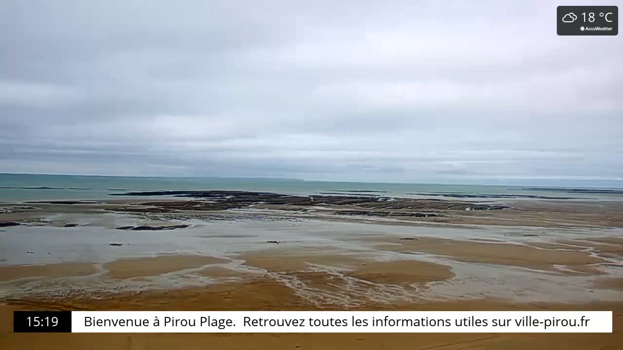 A wide sandy beach stretches to a calm, light-blue ocean under a cloudy sky.