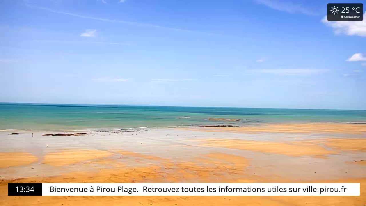 A sandy beach stretches out to a calm, turquoise ocean under a clear blue sky.