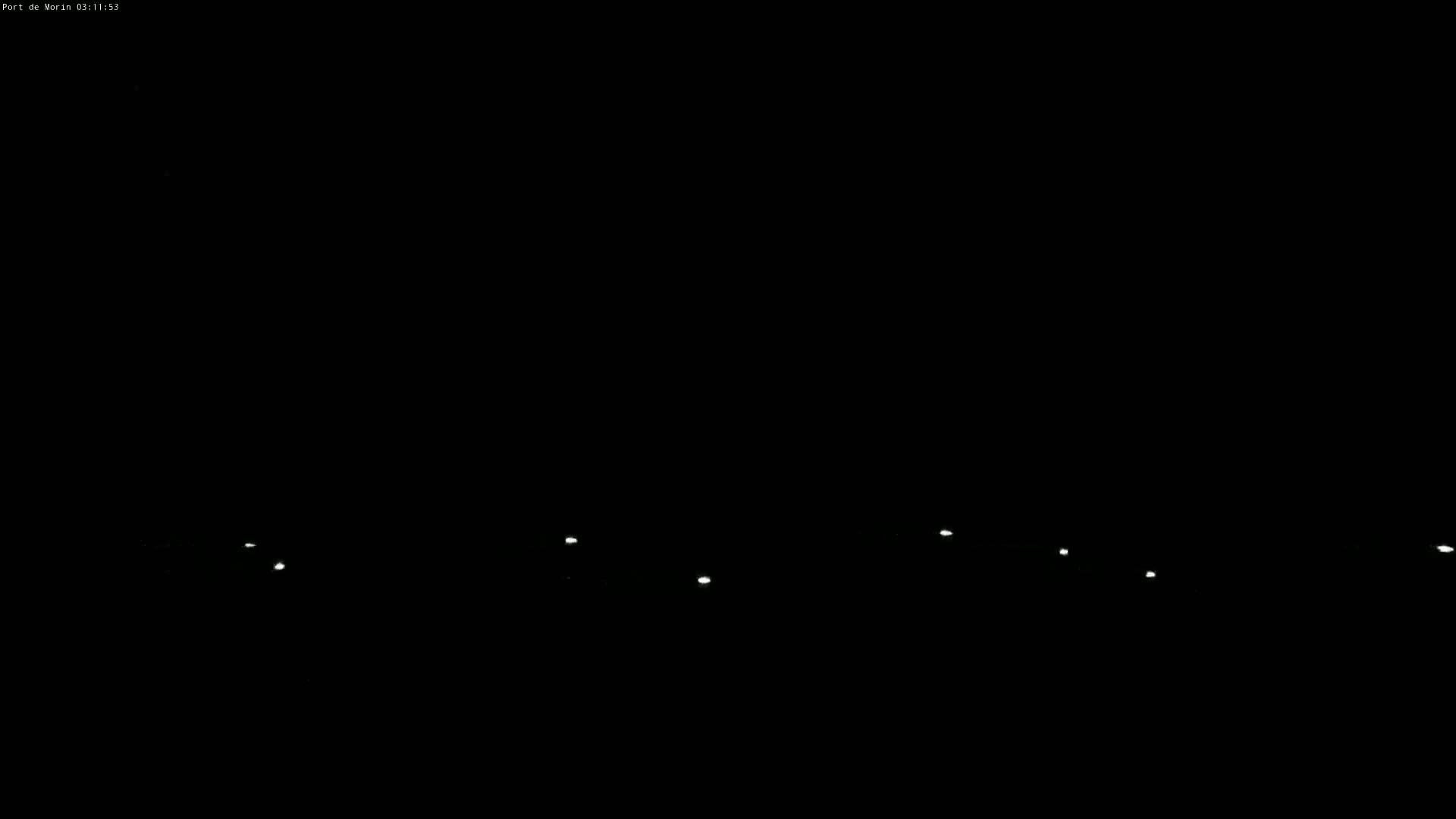 A series of faint lights are visible against a completely dark, nighttime sky.