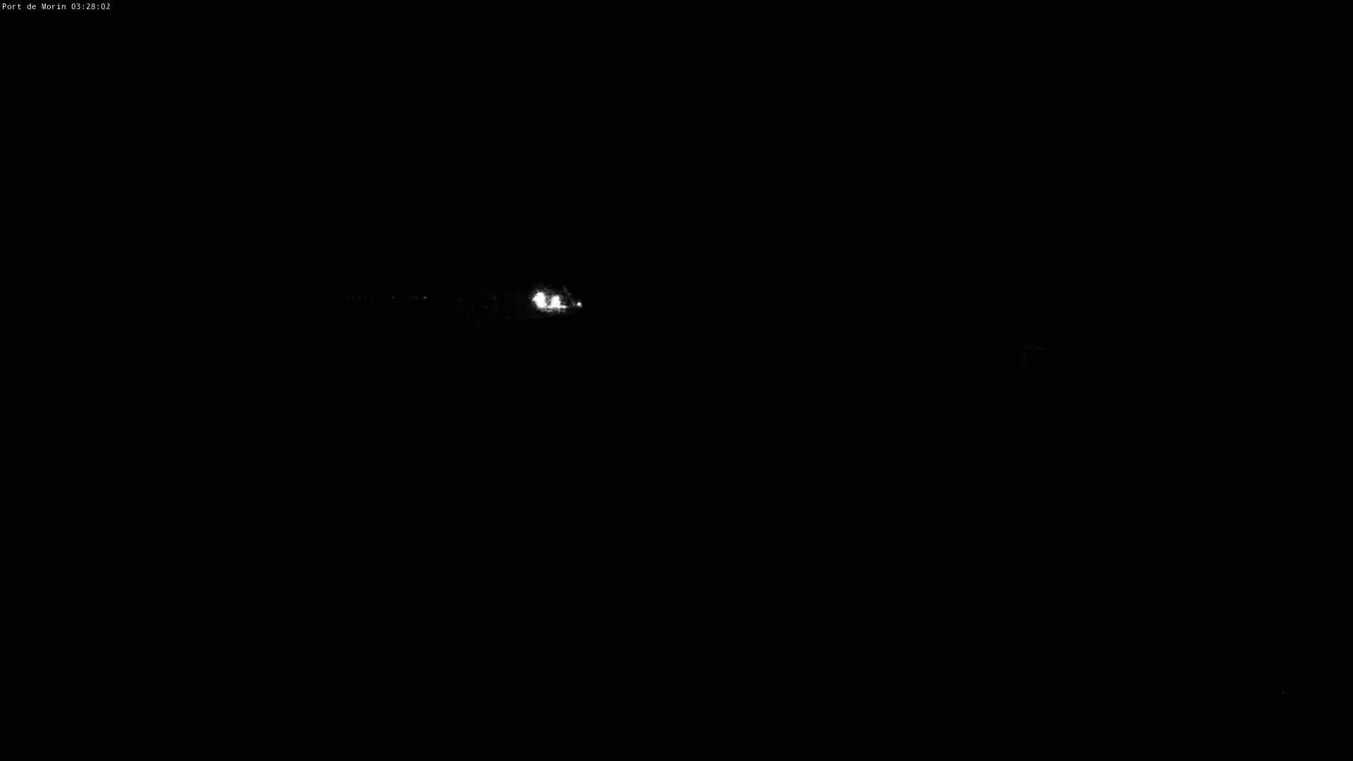 Faint white lights from a vehicle are visible in the distance at night.