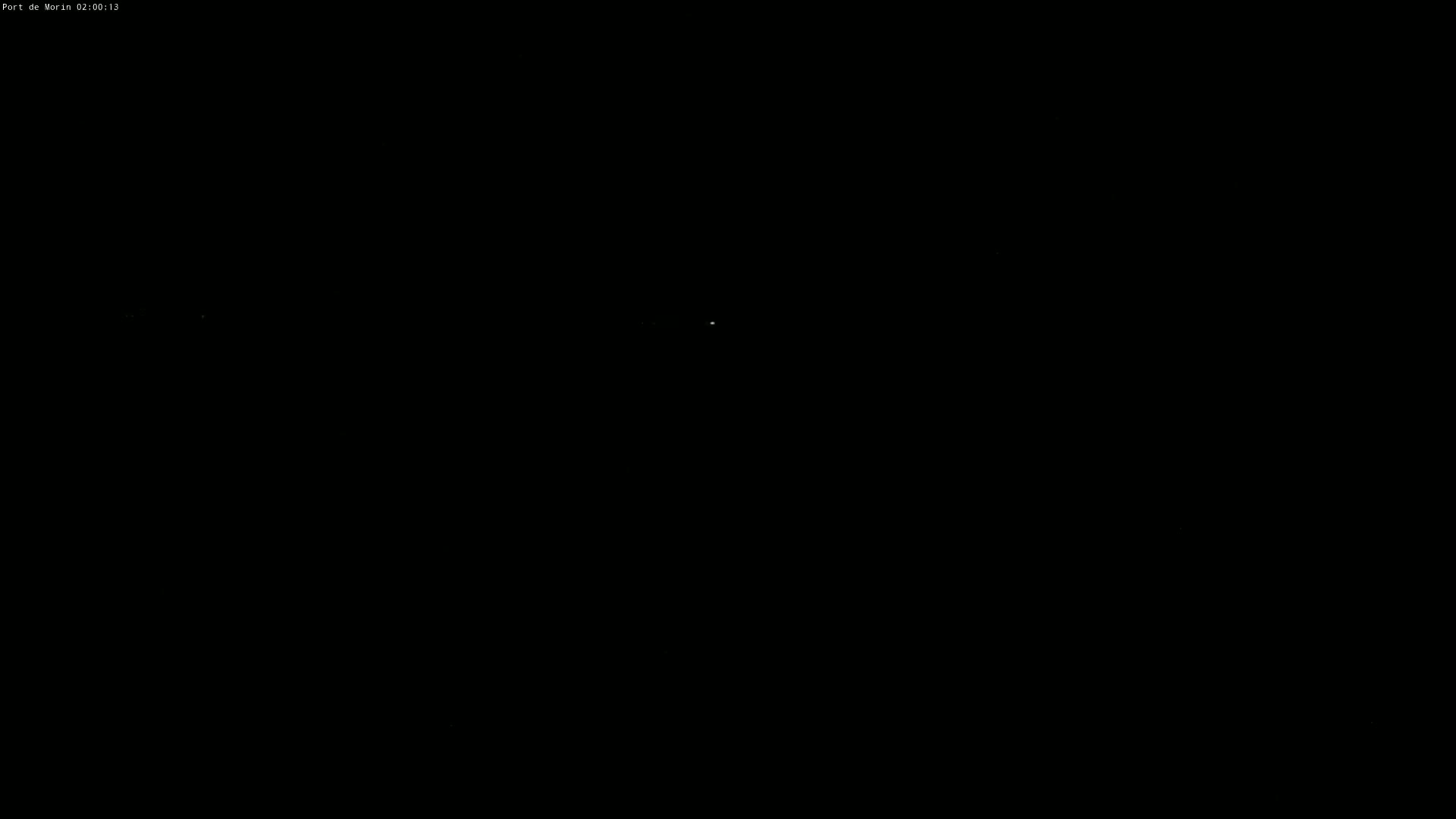 A dark, nighttime scene shows a few faint, distant lights.