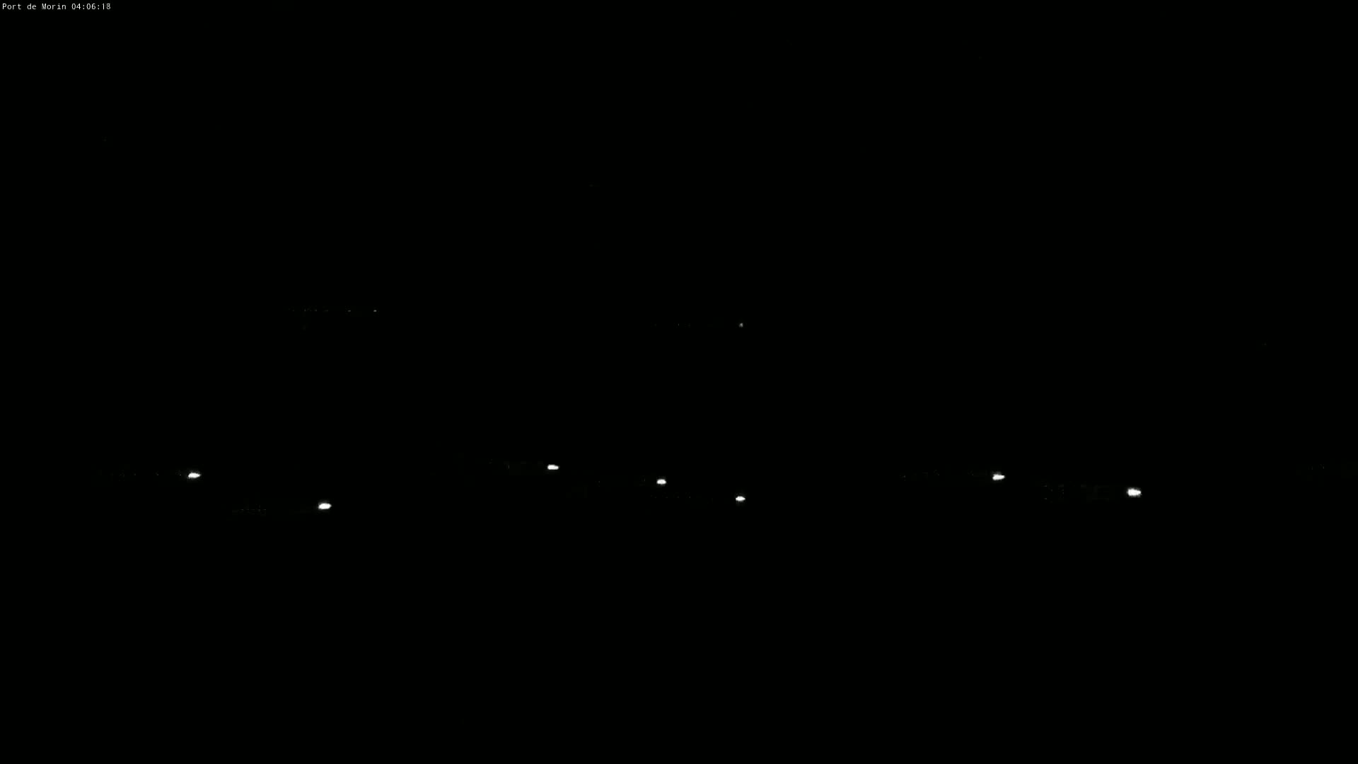 Several small, faint lights are visible in the darkness of night.