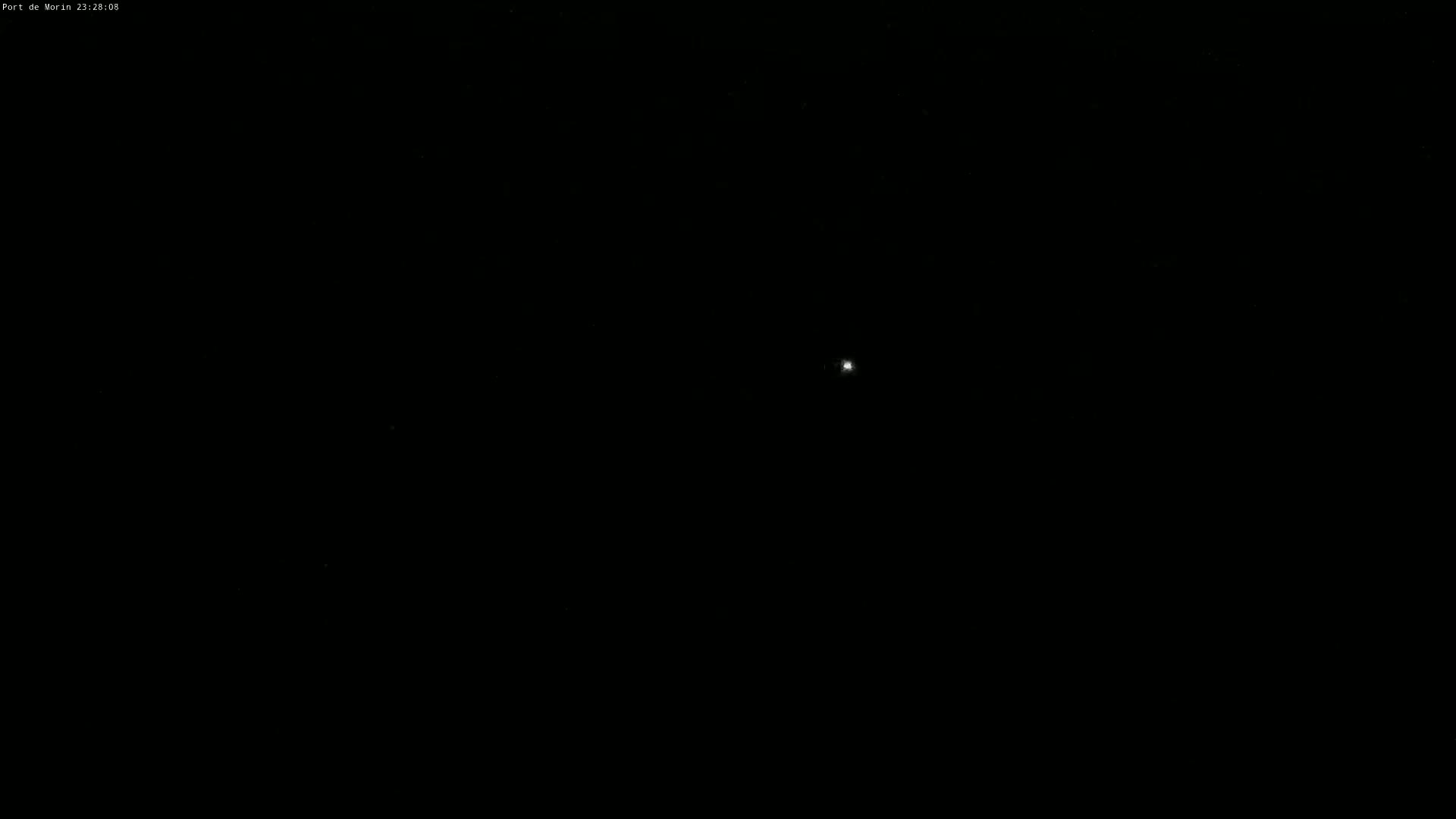 A bright light, possibly a star or planet, is visible in a completely dark night sky.