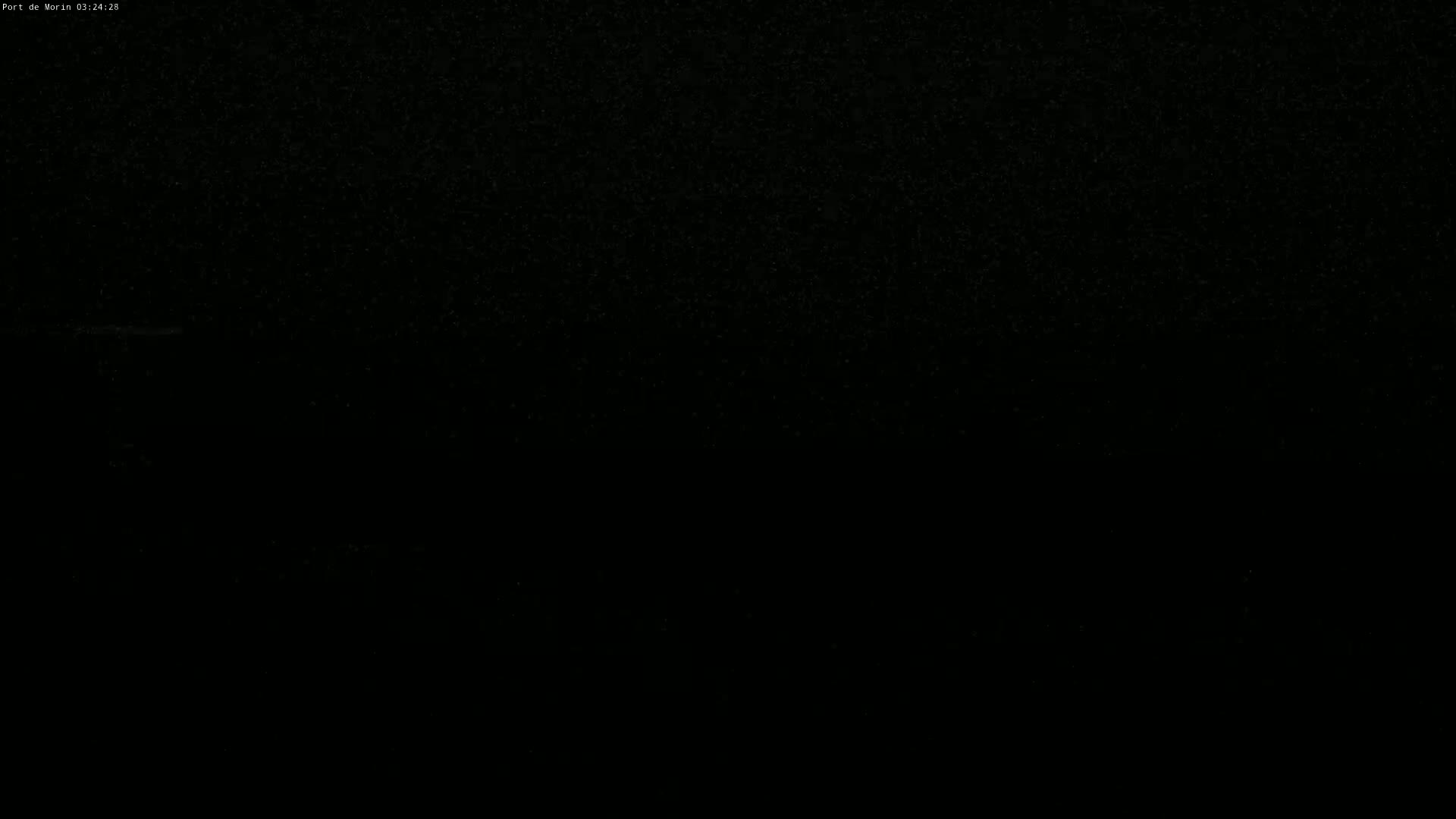 The image shows a dark, possibly nighttime scene with a faint, speckled texture suggesting light rain or snow.