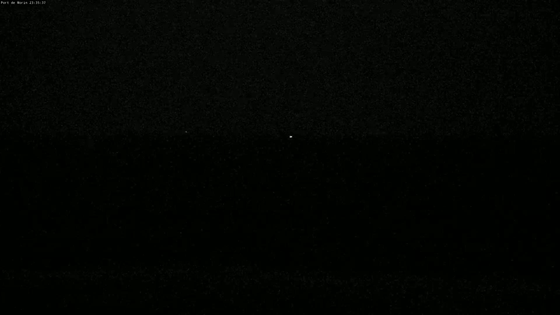 A nighttime, dark image shows two faint lights in the distance.