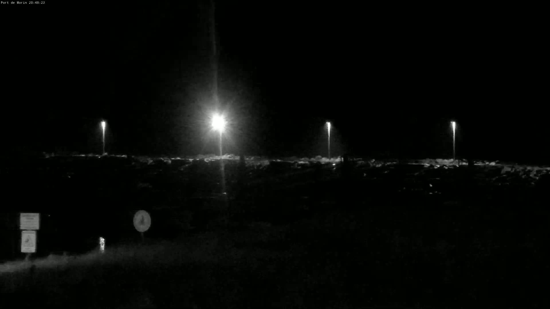 At night, several bright lights illuminate a dark, seemingly empty expanse of land.