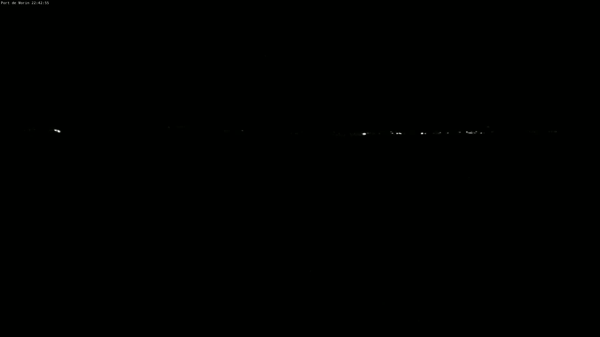 A nighttime long shot shows a faint line of distant lights on a dark horizon.