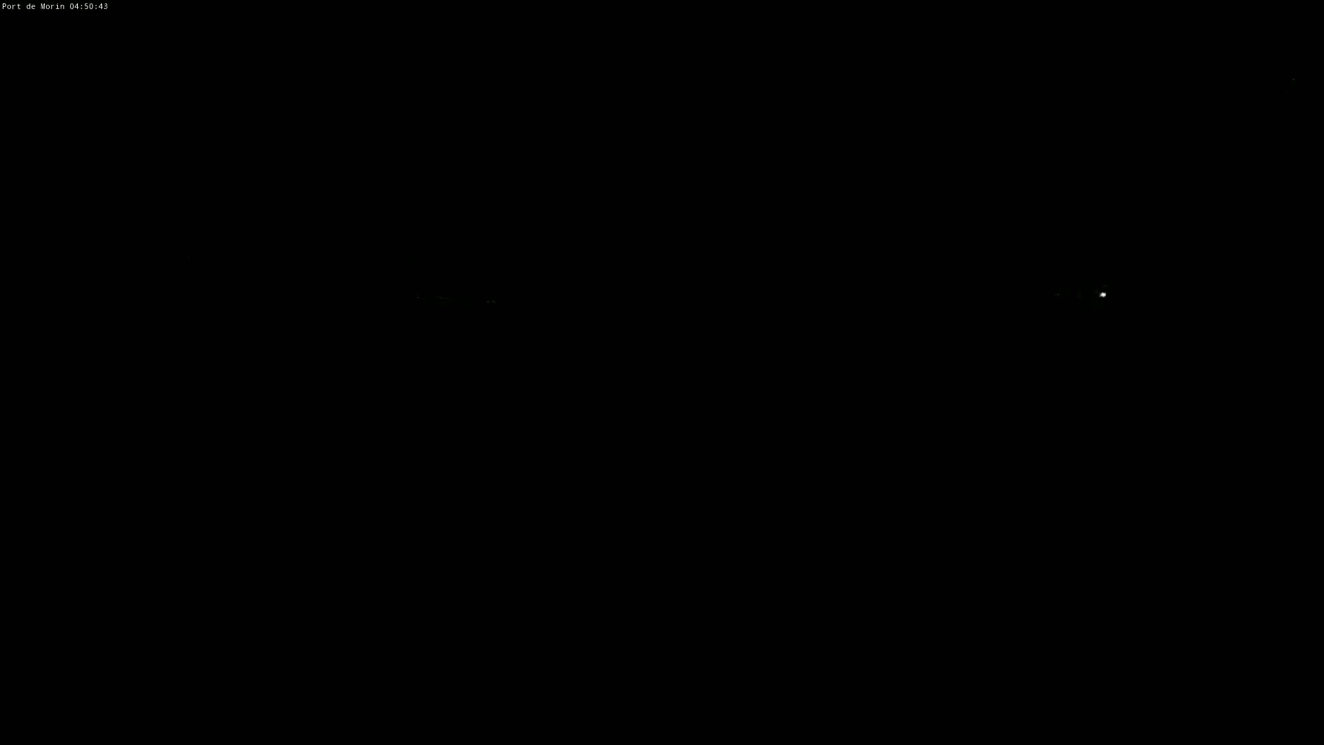 A very dark, nighttime image shows faint lights in the distance.