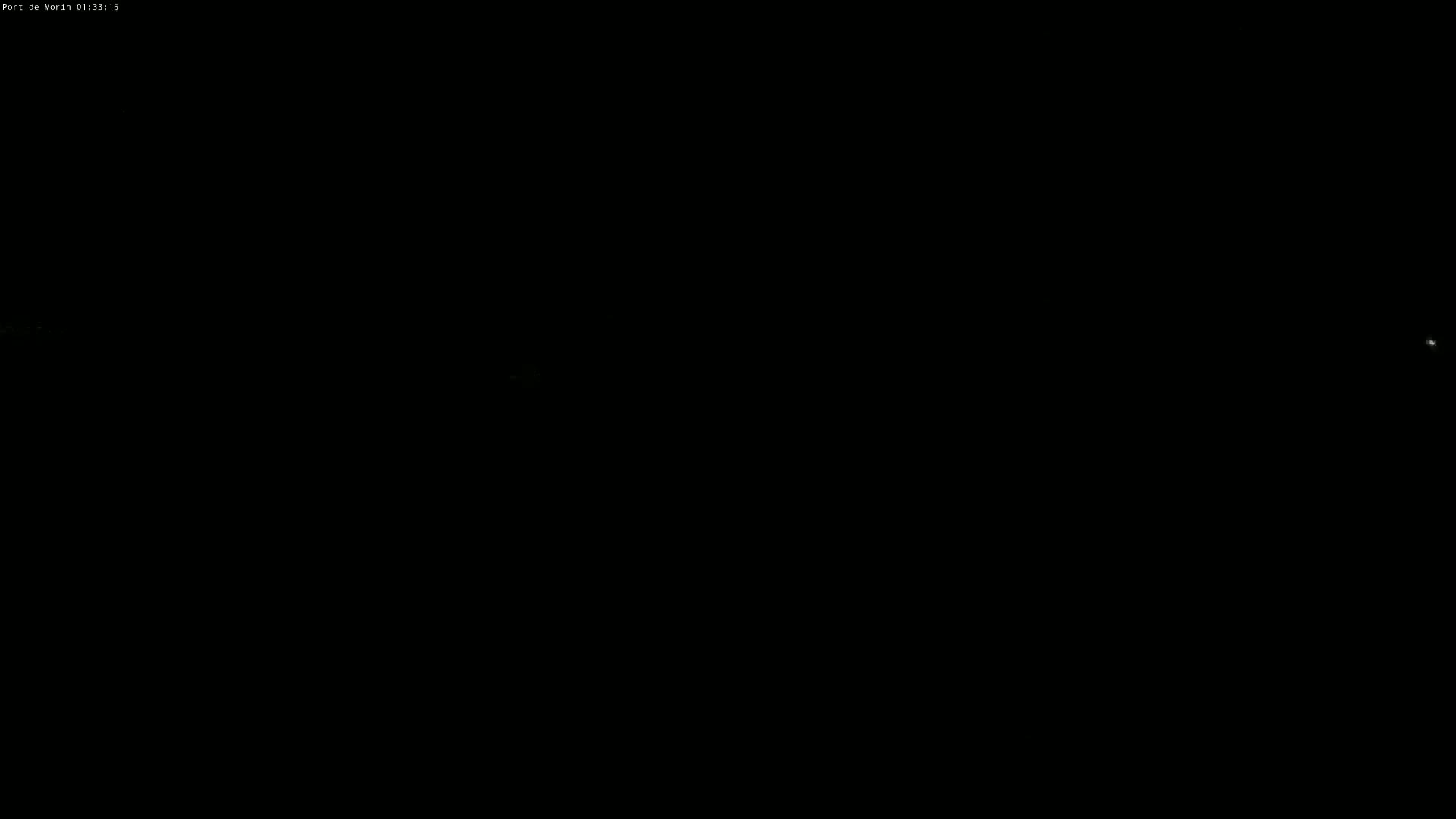 The image is almost entirely black, with a few faint, very small, light specks visible.