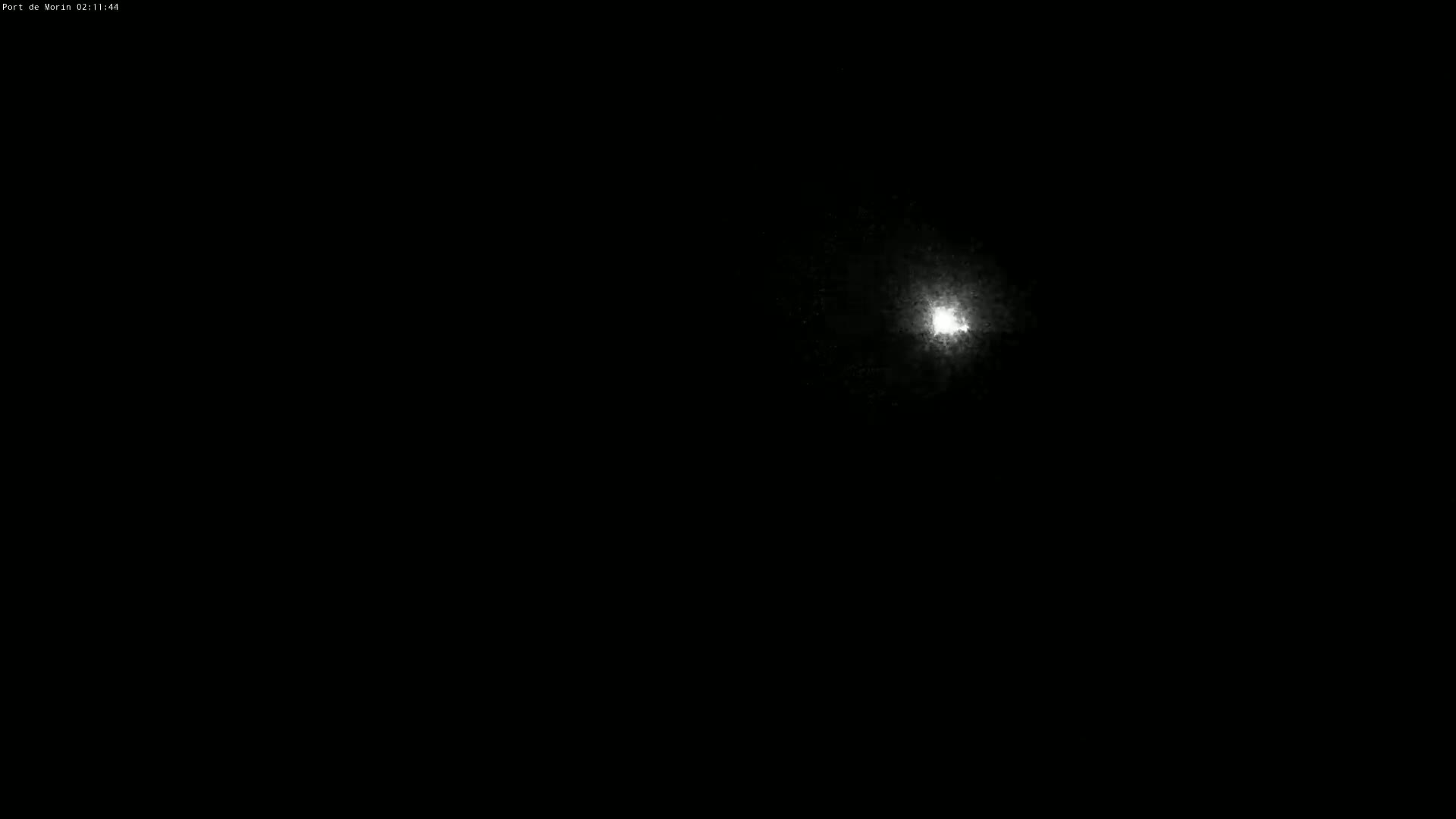 A bright light, possibly the moon, is visible in a dark, nighttime sky.