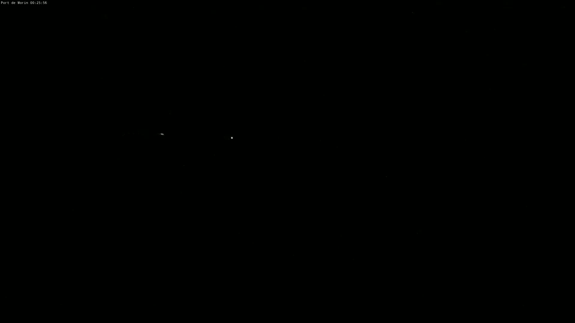 A dark nighttime scene shows two faint lights in the distance.