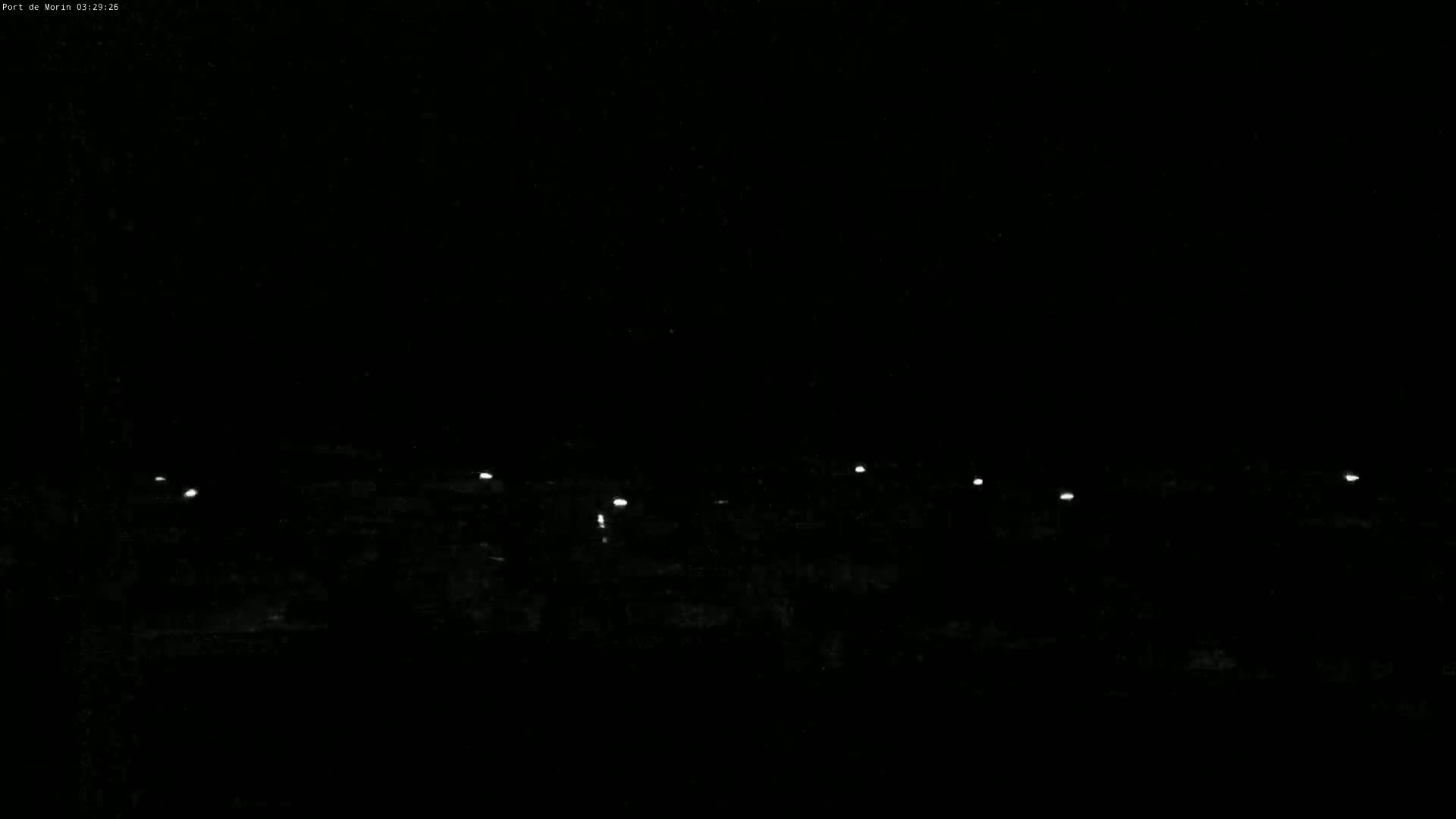 A nighttime view shows a dark landscape with several small, distant lights.
