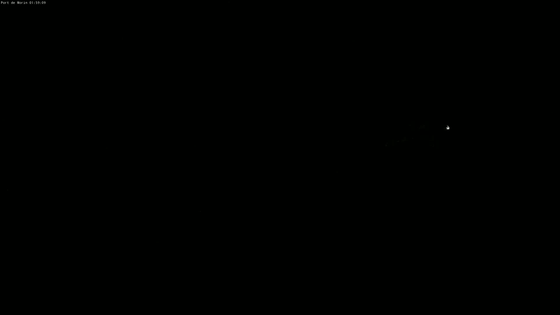 A dimly lit, dark scene at night shows a faint, distant light source.