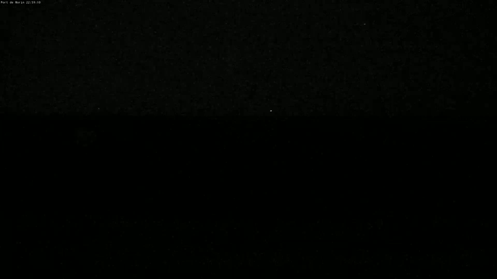 A nighttime image shows a dark sky with a single, faint light source in the distance.