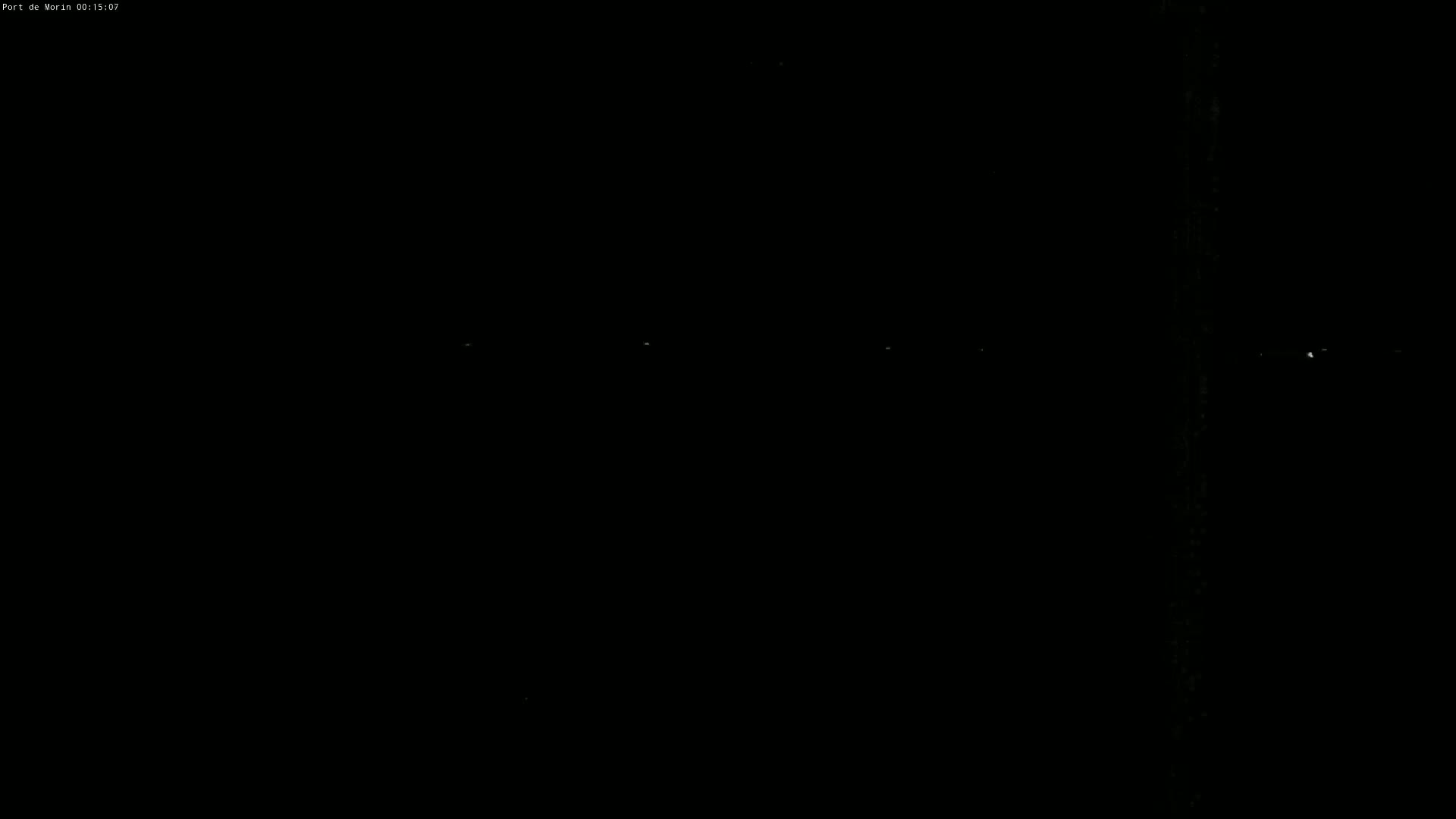 A dark nighttime scene shows a few faint lights in the distance.